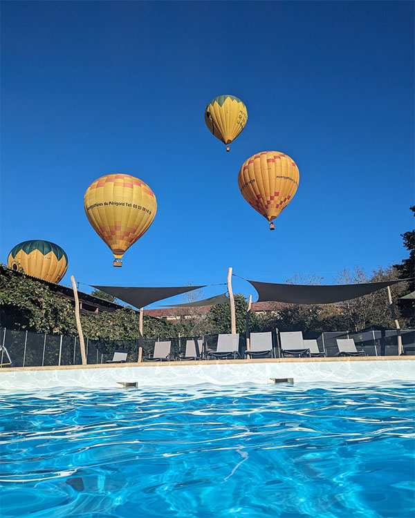 Montgolfiere survolant la piscine du camping les 5 chateaux en dordogne perigord noir